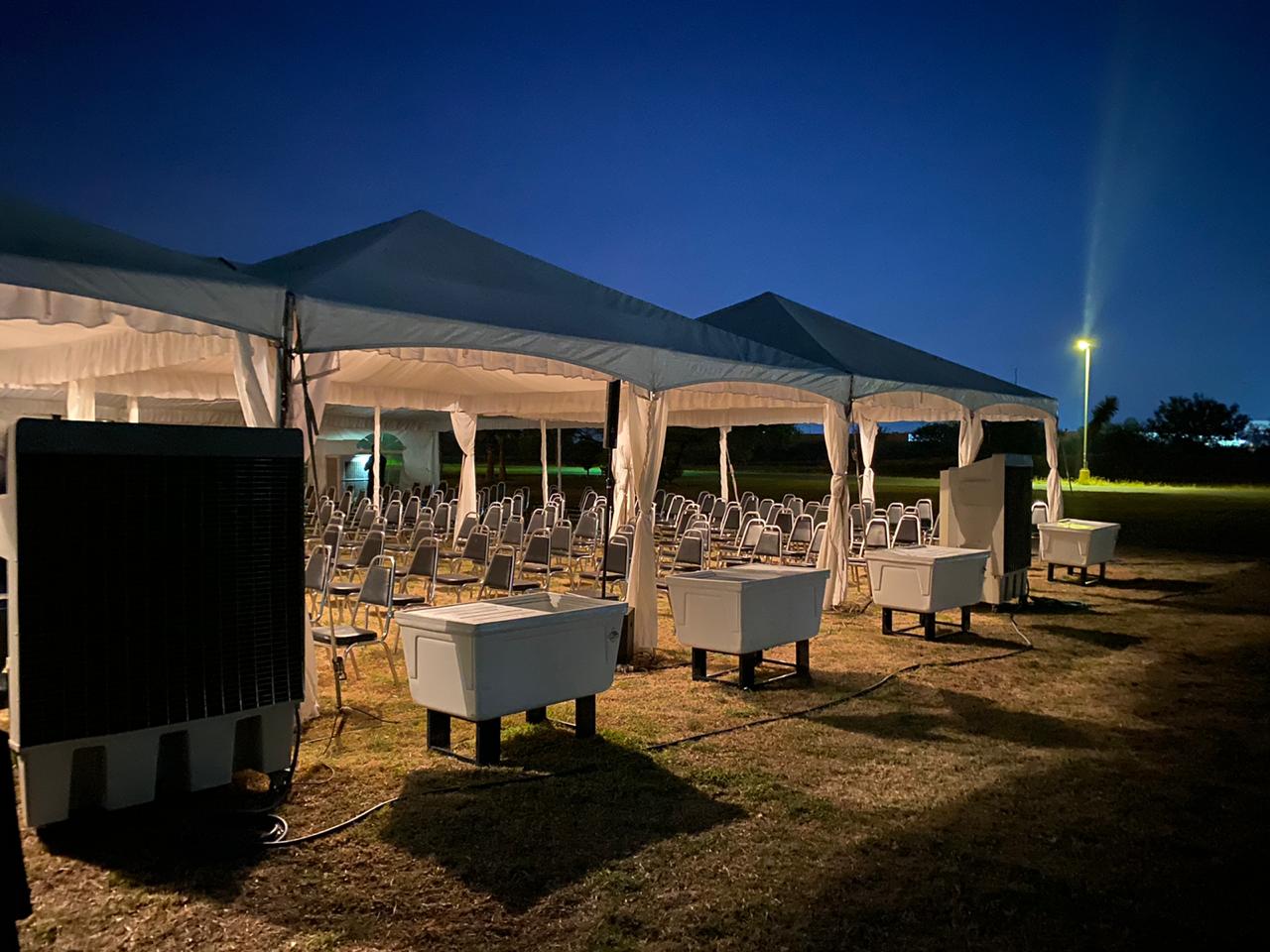 Equipos de enfriadores portátiles y sillas instaladas en evento nocturno de Carpa Real
